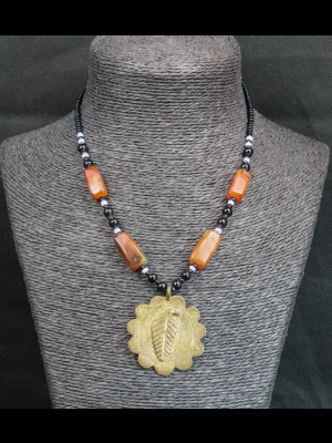Necklace with carnelian beads and a brass pendant