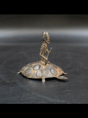 Old Dogon man sitting on a turtle